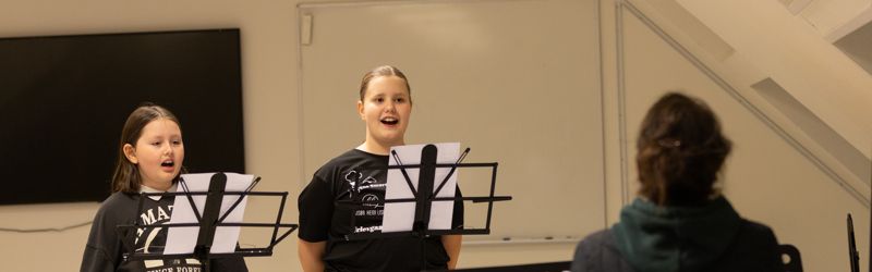 piger synger i mikrofon